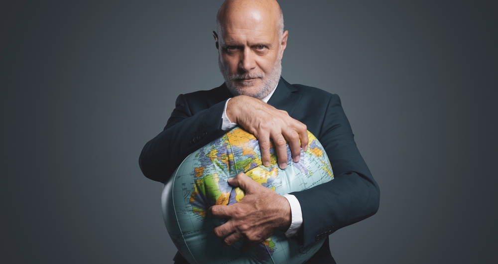 Picture of greedy businessman distoring a globe through extortion