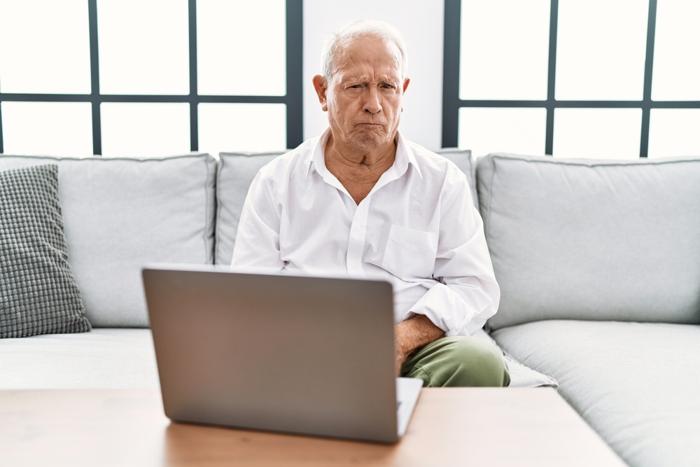 Grumpy old man sitting at laptop